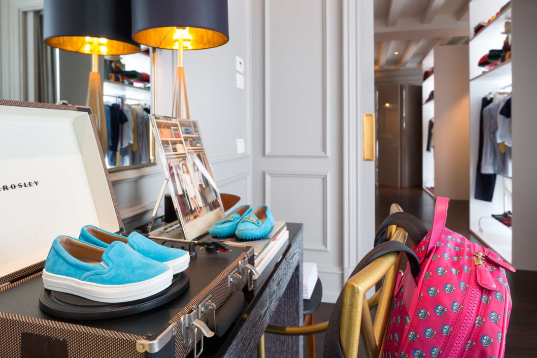 Mocassini azzurri appoggiati su un baule d'epoca davanti allo specchio della stanza