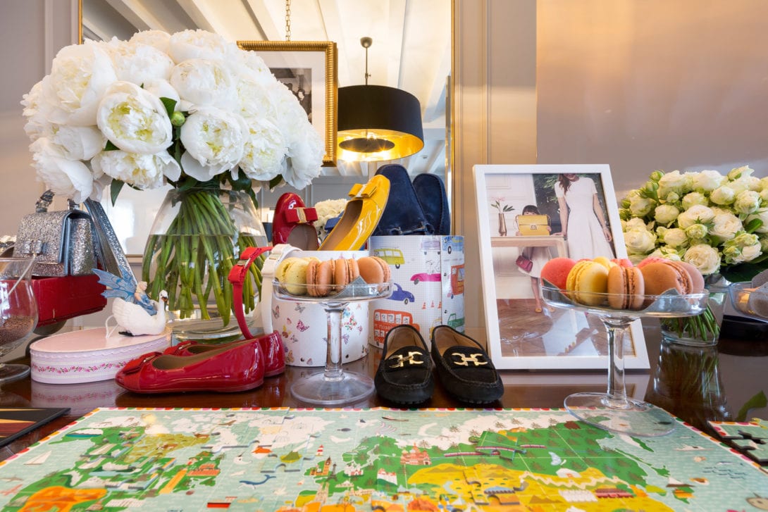 Tavolo allestito con fiori bianchi e articoli della nuova collezione Ferragamo