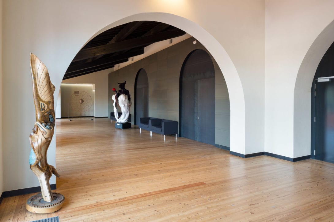 Foyer del Teatro Fonderia Leopolda con ampie arcate bianche e pavimento in legno