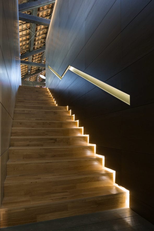 Elegante scala in legno con tagli di luce LED integrati, interior design in spazi storici