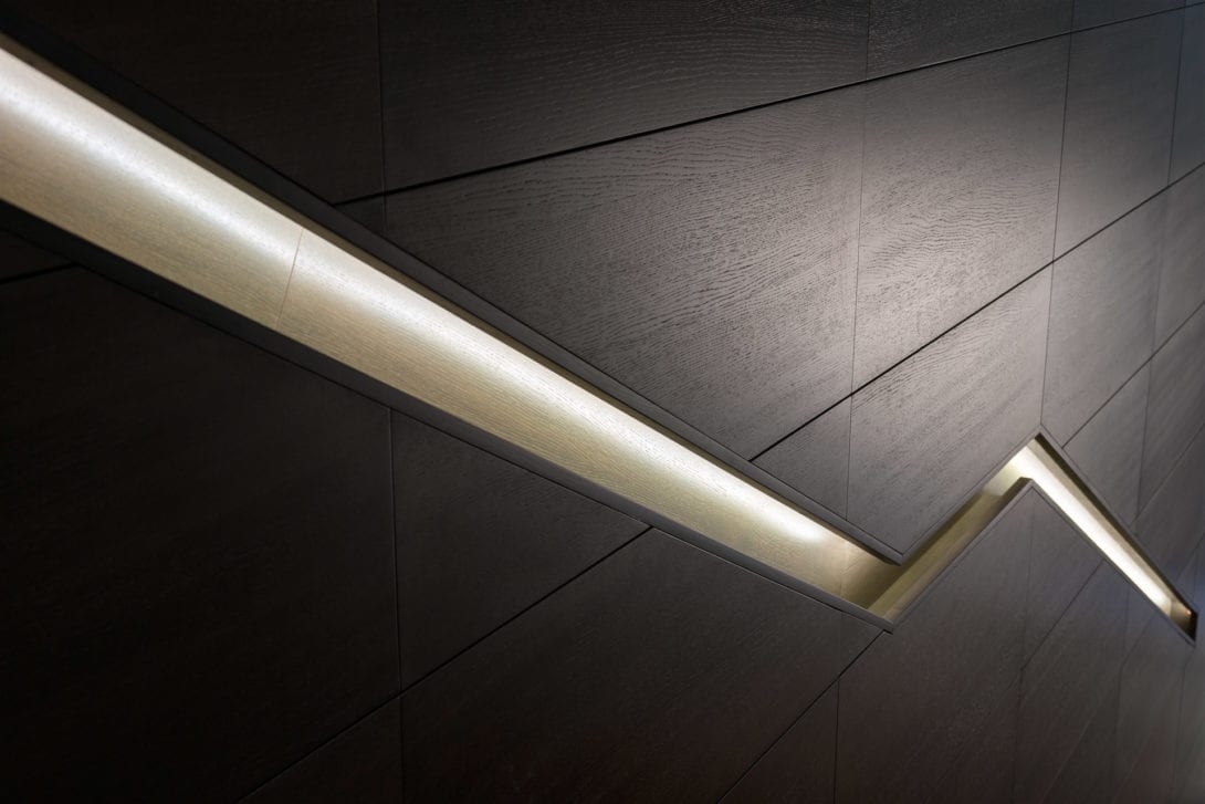 Particolare architettonico minimalista con illuminazione LED lineare su pannellatura materica